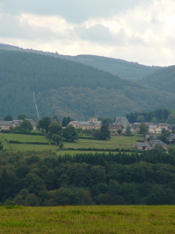 Photo Roussillon-en-Morvan - Le Bourg, au loin la conduite forcée cohabitant avec les résineux